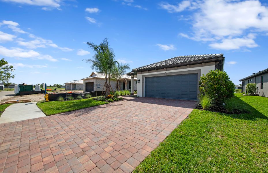Front exterior of a new home in Del Webb Naples, Ave Maria, FL, highlighting curb appeal (Image 2). Front exterior of a new home in Del Webb Naples, Ave Maria, FL, highlighting curb appeal (Image 2).