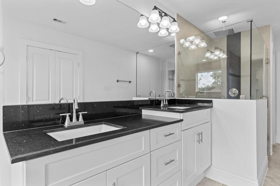 The primary spa bathroom features beautiful quartz countertops and backsplash paired with deep undermount his–and–hers private sinks. Take a moment to appreciate all the custom hardware throughout the home, from the elegant door handles to the thoughtfully selected fixtures and details that complete this stunning space. Rain style shower to melt that stress away! The primary spa bathroom features beautiful quartz countertops and backsplash paired with deep undermount his–and–hers private sinks. Take a moment to appreciate all the custom hardware throughout the home, from the elegant door handles to the thoughtfully selected fixtures and details that complete this stunning space. Rain style shower to melt that stress away!