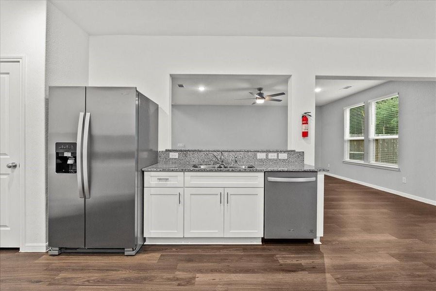 View of Kitchen towards the Living Room showing the Refrigerator staying with the home.