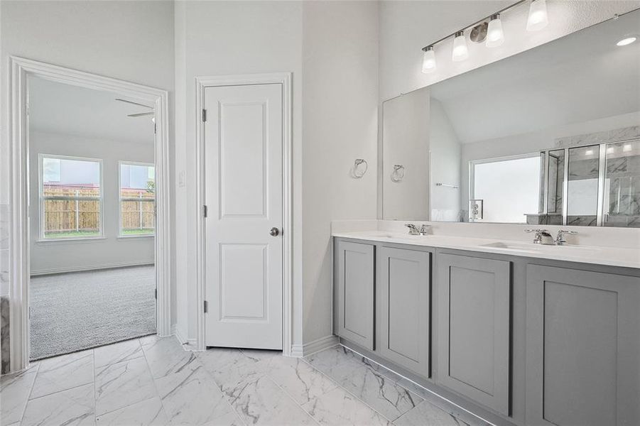 Bathroom with lofted ceiling, tile patterned flooring, and vanity