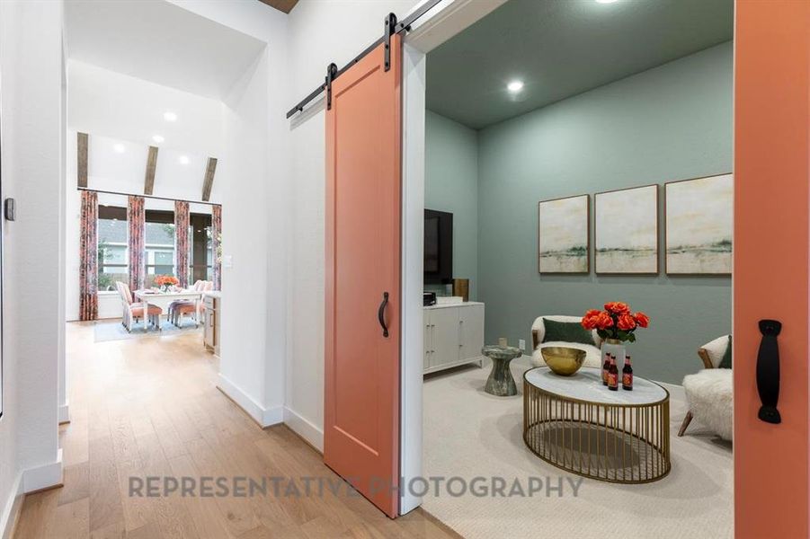 Hall featuring recessed lighting, light wood-style flooring, and a barn door