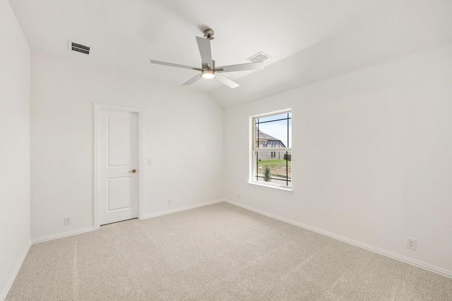 Empty bedroom with carpet flooring, vaulted ceiling, ceiling fan, and single window Empty bedroom with carpet flooring, vaulted ceiling, ceiling fan, and single window