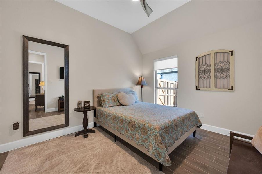 Spacious secondary bedroom with walk in closet, ceiling fan, wood look tile flooring in a neutral color scheme at 13' x 11'