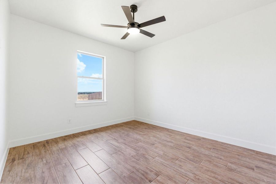 A well-lit room showcases durable wood-look tile flooring and a sleek ceiling fan for optimal comfort. A well-lit room showcases durable wood-look tile flooring and a sleek ceiling fan for optimal comfort.