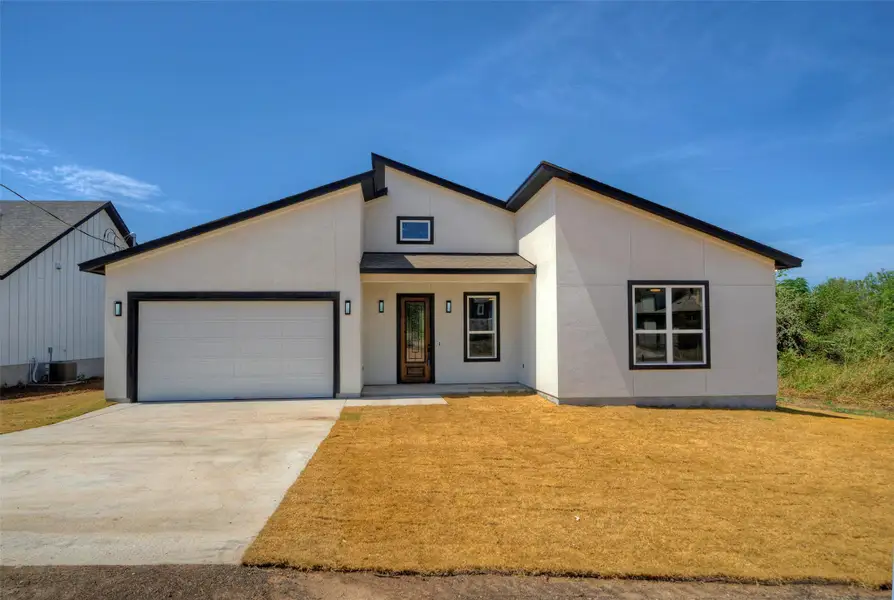 Clean modern architectural lines frame this newly constructed stucco residence under a clear blue sky. Clean modern architectural lines frame this newly constructed stucco residence under a clear blue sky.