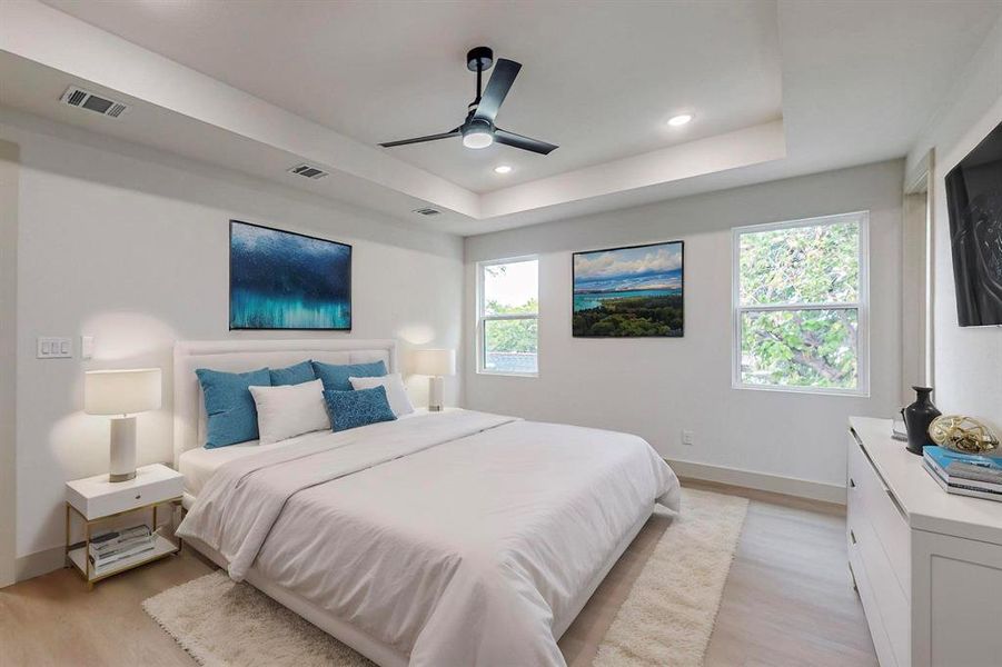 Bedroom featuring light wood-type flooring, multiple windows, and ceiling fan