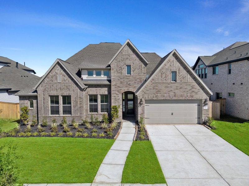 Front exterior of a new home in Valencia 70', Manvel, TX, highlighting curb appeal (Image 2).
