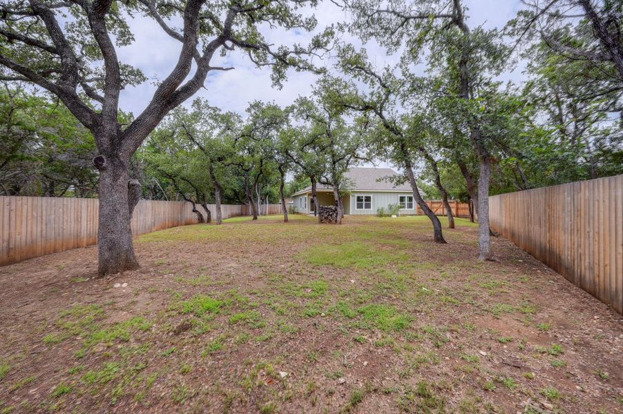 Secluded yard with mature shade trees, offering ample space for recreation and relaxation. Secluded yard with mature shade trees, offering ample space for recreation and relaxation.