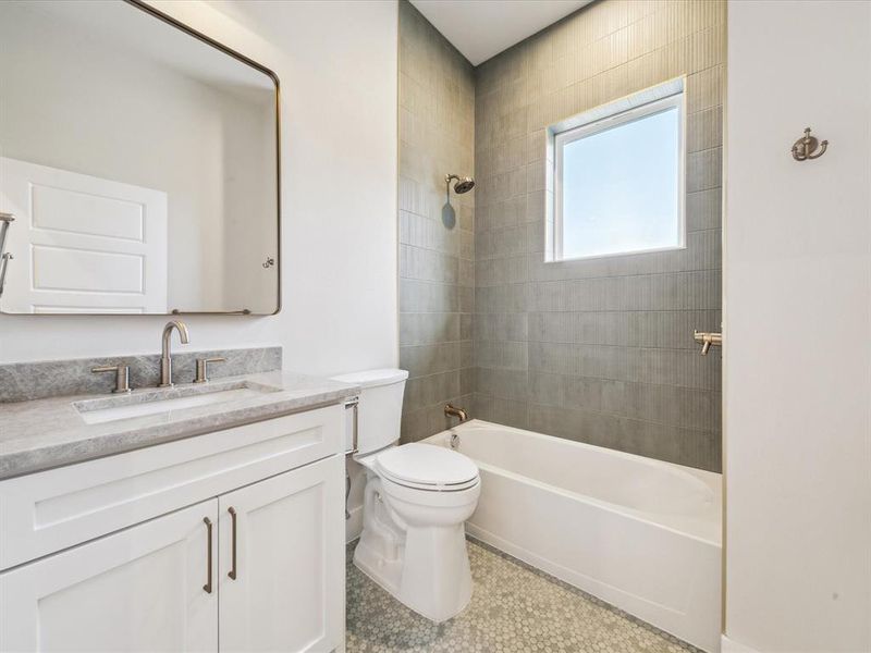 Full bathroom with tile patterned flooring, vanity, toilet, and tiled shower / bath