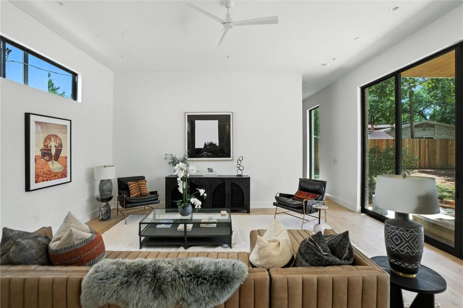 Living room featuring light wood-style floors and ceiling fan Living room featuring light wood-style floors and ceiling fan