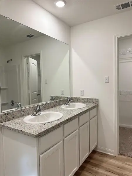 The primary bathroom includes granite countertops, double vanities, enclosed water closet and a walk-in closet.