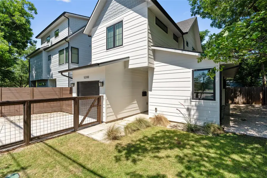 Modern multi-story exterior with white horizontal siding and dark trim windows. Fully fenced front yard with a side entrance gate off the driveway. Beautifully landscaped with automatic in ground sprinkler system. Modern multi-story exterior with white horizontal siding and dark trim windows. Fully fenced front yard with a side entrance gate off the driveway. Beautifully landscaped with automatic in ground sprinkler system.