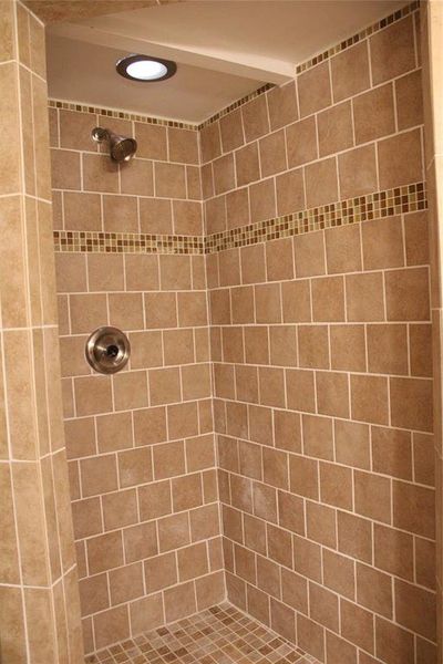 Full bathroom featuring tiled shower Full bathroom featuring tiled shower