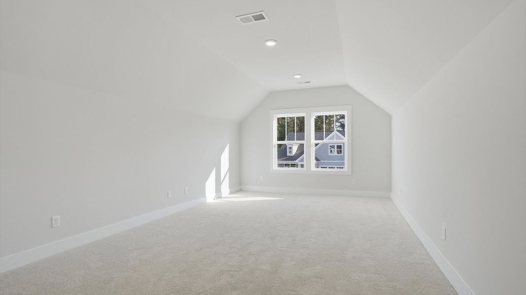 Vibrant carpeted bonus room offering flexibility as a study nook, game room, or second family space at Pelham Crossing