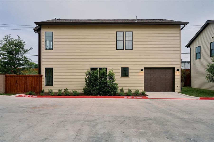 Two-story structure featuring tan horizontal siding and dark trim windows