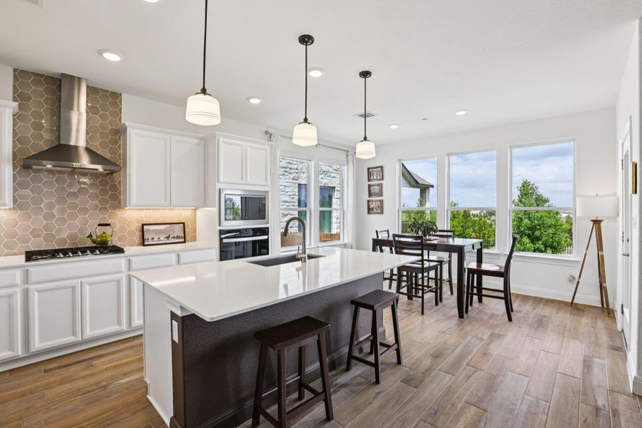 Modern kitchen with white cabinetry, a large kitchen island, and stainless steel appliances