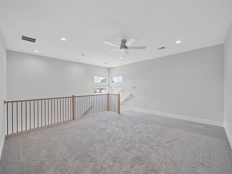 Carpeted game room with ceiling fan