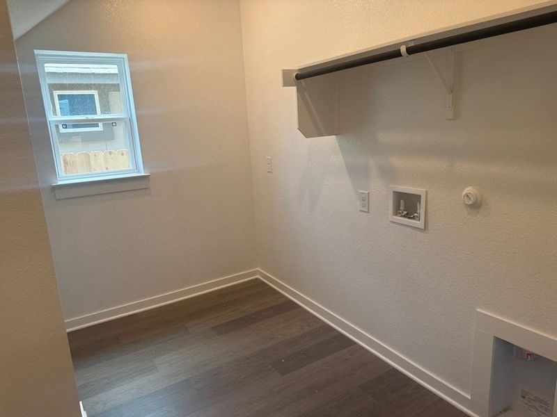 Laundry room with a textured wall, dark wood-style floors, hookup for a gas dryer, and washer hookup Laundry room with a textured wall, dark wood-style floors, hookup for a gas dryer, and washer hookup