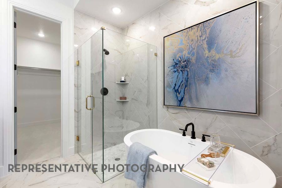 Bathroom with a marble finish shower, a walk in closet, tile walls, a freestanding tub, and marble finish floors Bathroom with a marble finish shower, a walk in closet, tile walls, a freestanding tub, and marble finish floors