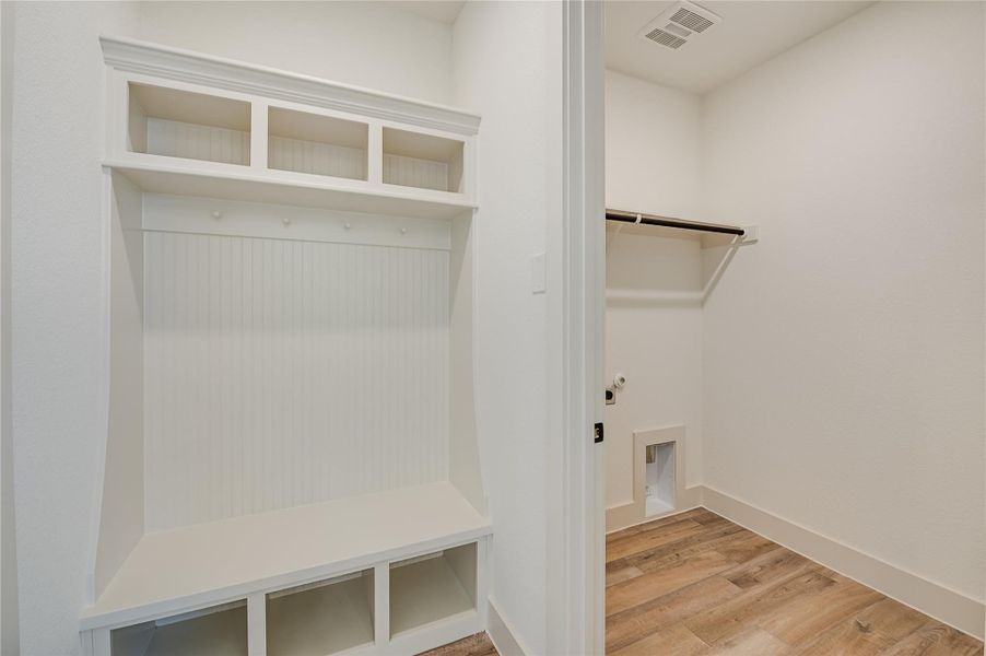Mudroom featuring light wood-style floors and baseboards