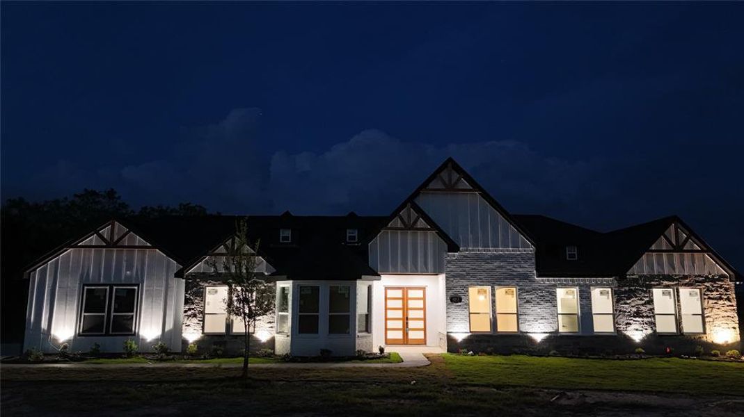 View of front of house with french doors and a lawn