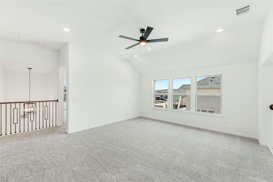 Spacious upstairs bonus room with vaulted ceiling, ceiling fan, carpet flooring, and open stair railing Spacious upstairs bonus room with vaulted ceiling, ceiling fan, carpet flooring, and open stair railing