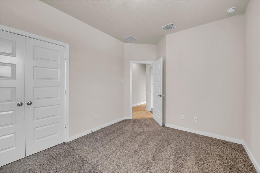 Unfurnished bedroom featuring a closet and carpet