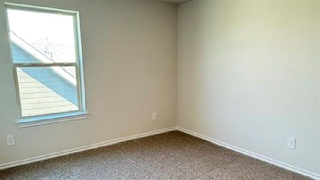 Empty room featuring carpet and baseboards