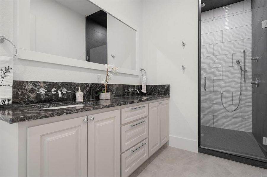 Bathroom with light tile patterned floors, a stall shower, and double vanity Bathroom with light tile patterned floors, a stall shower, and double vanity