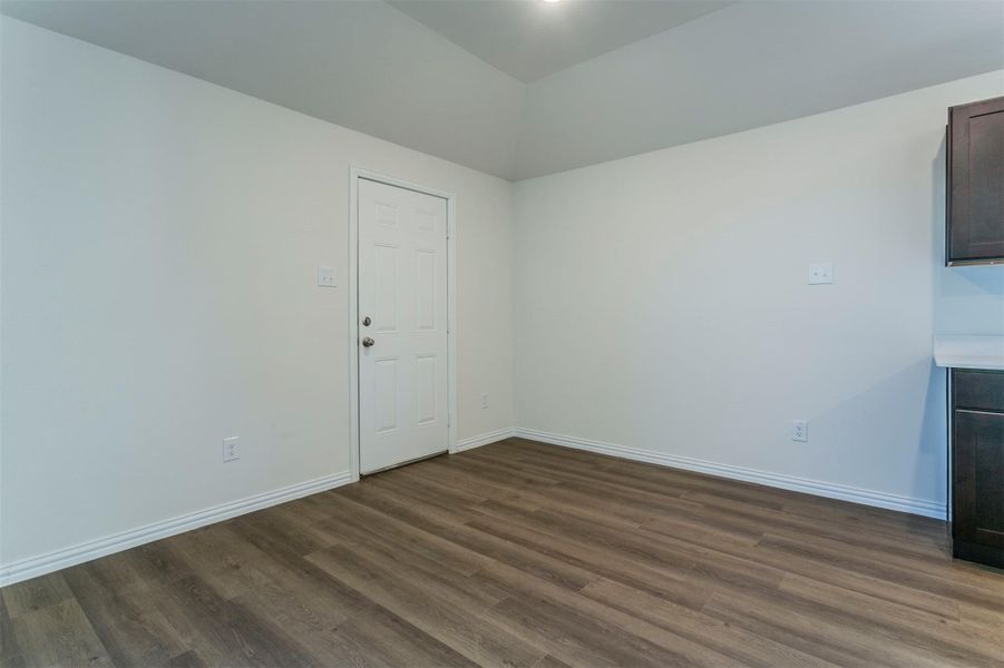 Unfurnished room with baseboards and dark wood-style floors Unfurnished room with baseboards and dark wood-style floors