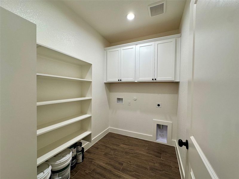 Laundry room with electric dryer hookup, dark wood finished floors, gas dryer hookup, washer hookup, and cabinet space Laundry room with electric dryer hookup, dark wood finished floors, gas dryer hookup, washer hookup, and cabinet space