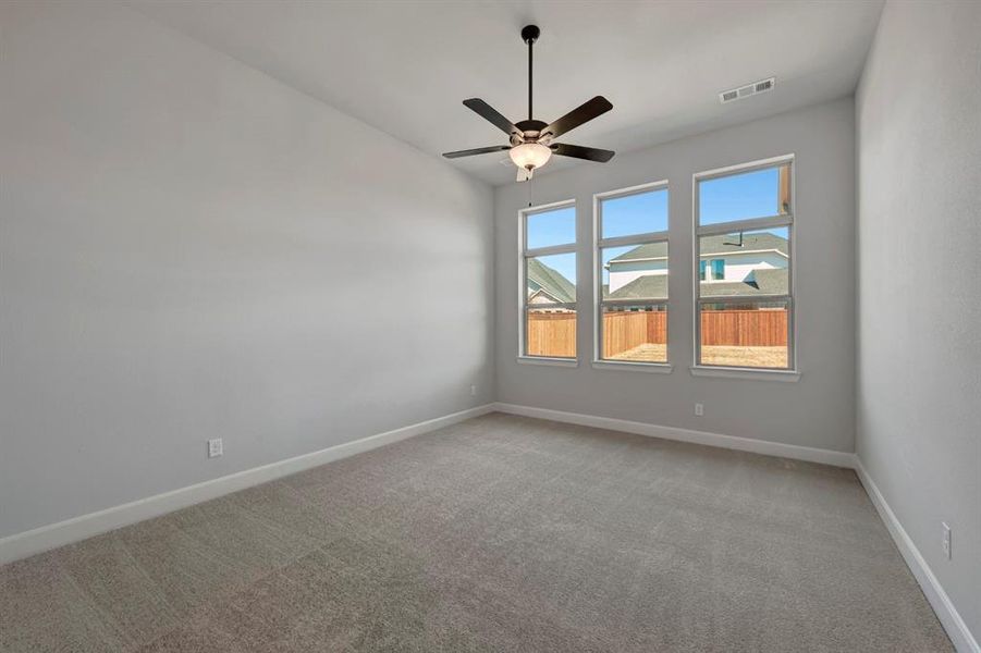 Empty room featuring light carpet and a ceiling fan