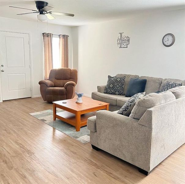 Living room with light wood-style flooring and ceiling fan Living room with light wood-style flooring and ceiling fan
