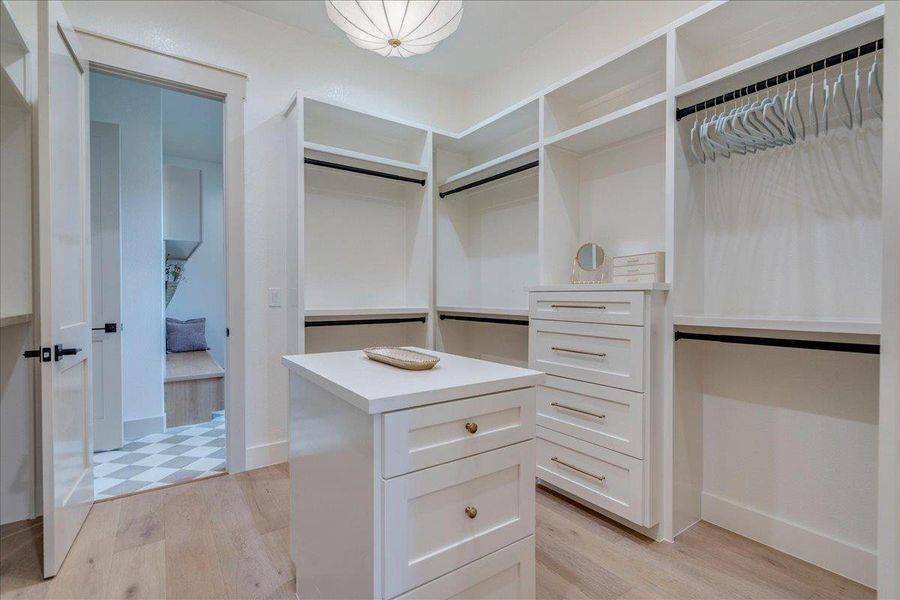 Ample built-in storage solutions create an organized and airy dressing area.