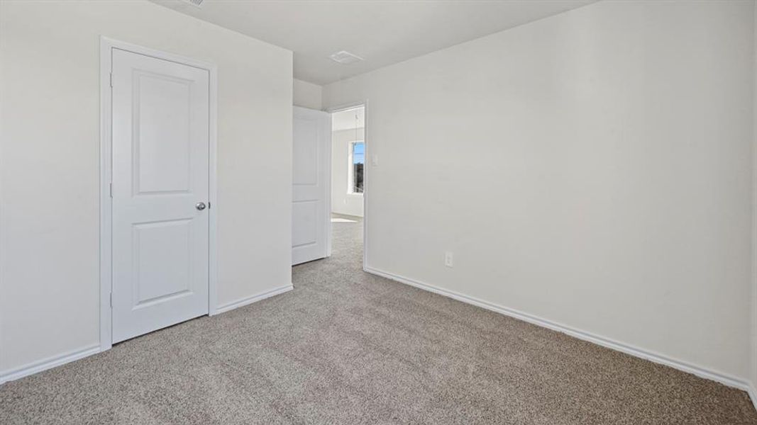 Neutral tone wall finishes, gray carpeting, and white trim work