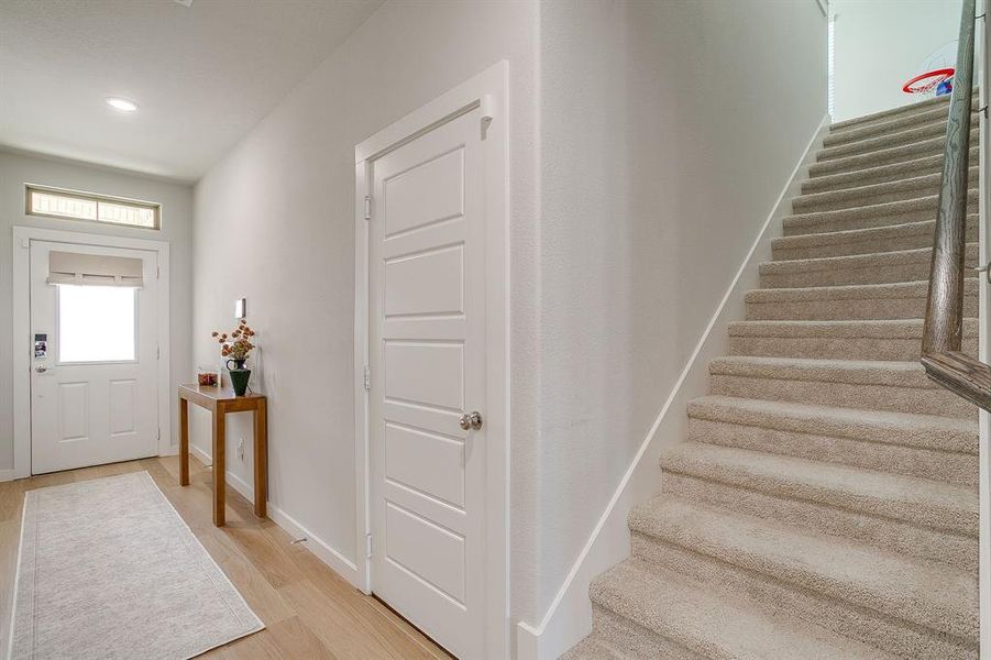 Foyer entrance featuring light wood-type flooring and stairway Foyer entrance featuring light wood-type flooring and stairway