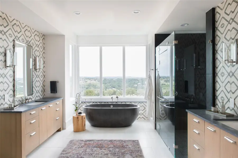 Full bath with vanity, a stall shower, a freestanding bath, light tile patterned floors, and tile walls