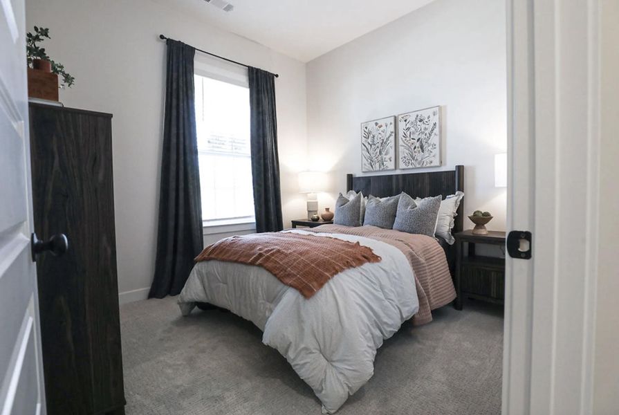 Carpeted room featuring a window with dark drapery panels, light wall paint, and a dark wood-finish headboard