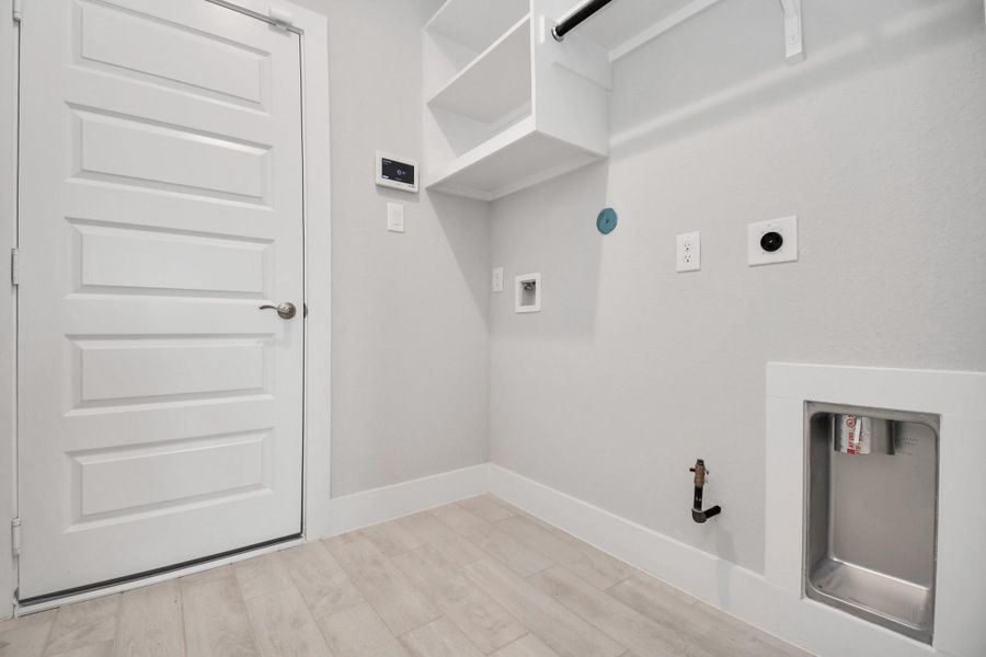 A perfect blend of functionality and comfort. Capture the essence of easy living with a first-floor laundry room, thoughtfully equipped with shelving for effortless organization. Both electric and gas connections available. Sample photo of completed home with similar floor plan. Actual colors and selections may vary. A perfect blend of functionality and comfort. Capture the essence of easy living with a first-floor laundry room, thoughtfully equipped with shelving for effortless organization. Both electric and gas connections available. Sample photo of completed home with similar floor plan. Actual colors and selections may vary.