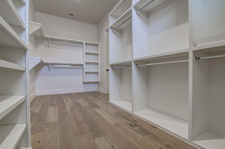 Walk in closet featuring wood finished floors Walk in closet featuring wood finished floors