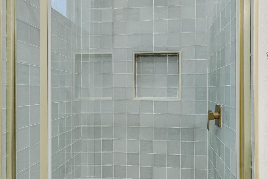 A sleek, tiled shower with integrated niches offers practical storage.