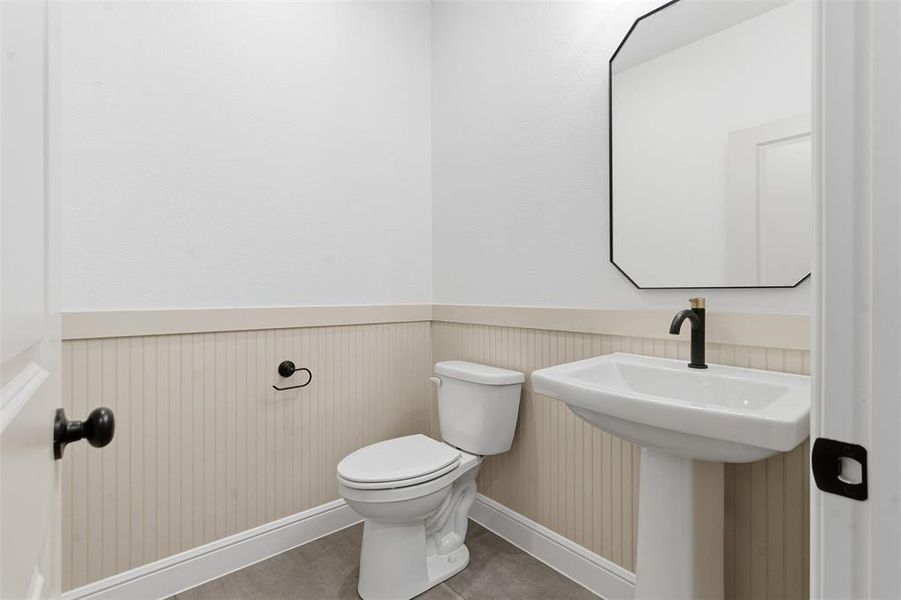 Half bath with wainscoting and tile patterned floors Half bath with wainscoting and tile patterned floors