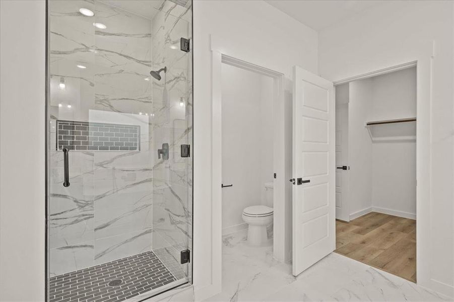 Bathroom with toilet and a shower with shower door