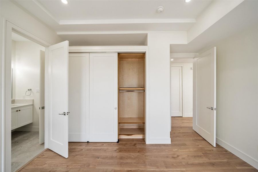 Bright, secondary bedroom with wood flooring, a built-in closet, and adjacent access to a Jack & Jill bathroom, offering a clean and functional living space.