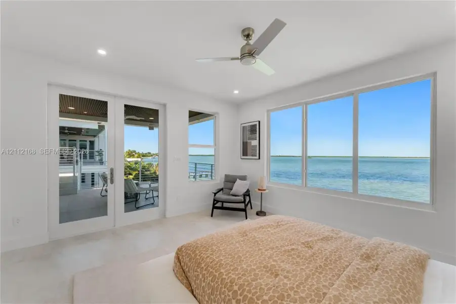 Floor-to-ceiling windows, double glass doors with access to the exterior, recessed lighting, brushed nickel ceiling fan, and light-toned tile flooring Floor-to-ceiling windows, double glass doors with access to the exterior, recessed lighting, brushed nickel ceiling fan, and light-toned tile flooring