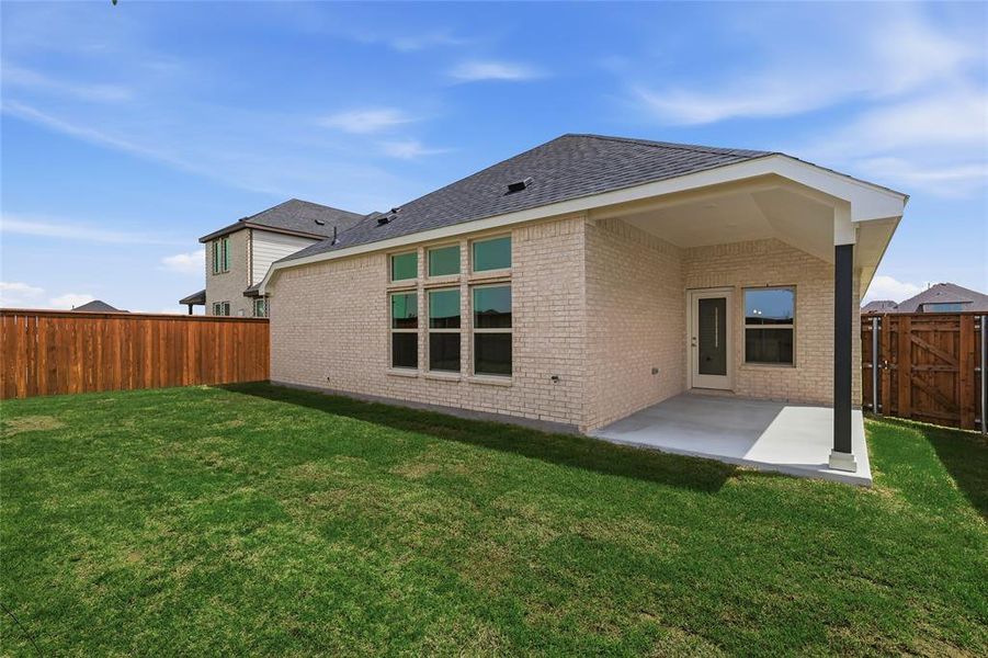 Back of house featuring a fenced backyard, a gate, a patio, brick siding, and a shingled roof