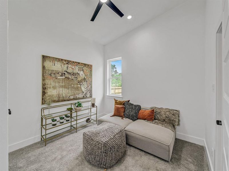 Living area with ceiling fan, vaulted ceiling, and carpet