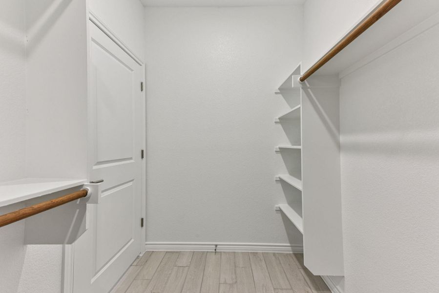 Spacious closet featuring light wood-style floors Spacious closet featuring light wood-style floors