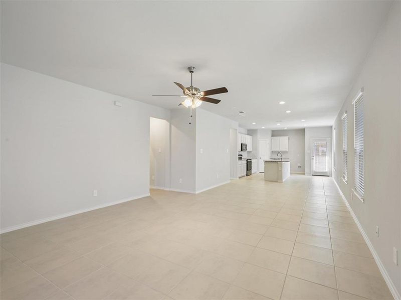 Unfurnished living room with recessed lighting, a sink, light tile patterned floors, ceiling fan, and baseboards Unfurnished living room with recessed lighting, a sink, light tile patterned floors, ceiling fan, and baseboards