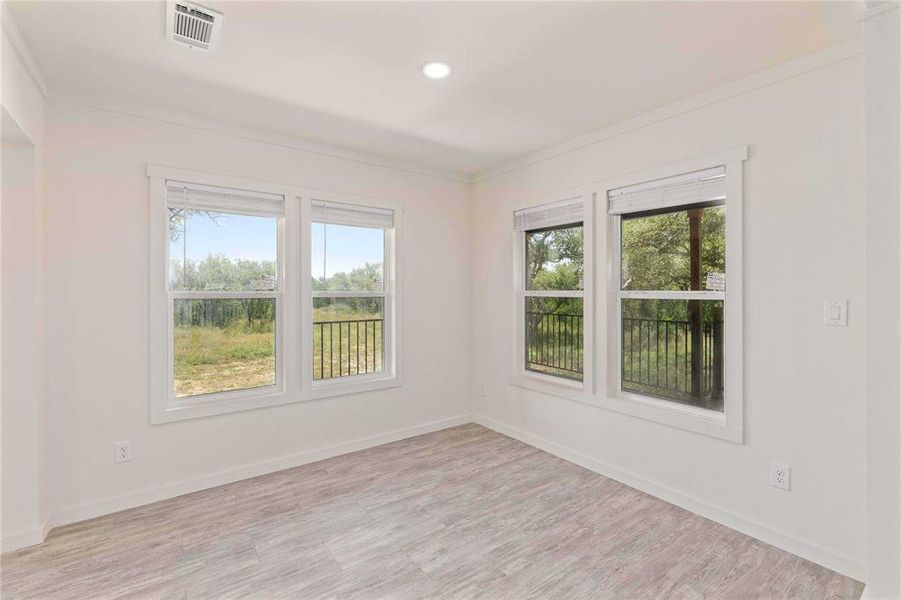 Bright room featuring wood-finish flooring and recessed lighting